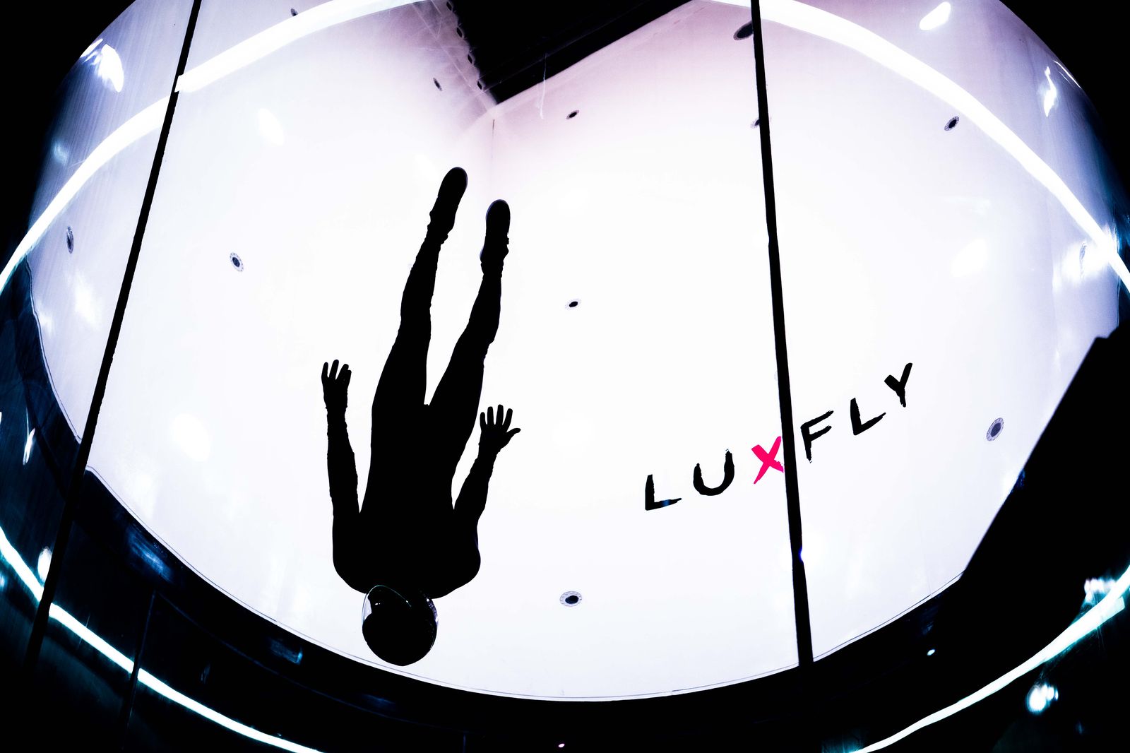 Silhouette vun engem Flyer an der Fluchkummer vu LUXFLY, dem h&eacute;chsten Indoor-Skydiving-Simulator an Europa