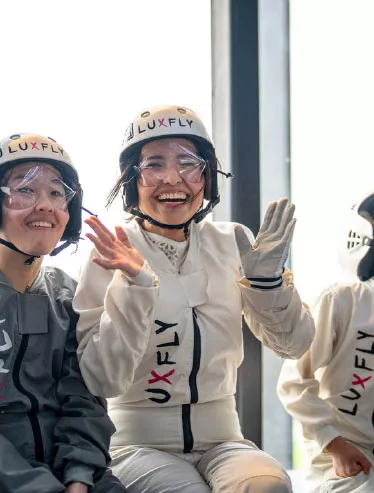 Smiling flyers in LUXFLY suits and helmets
